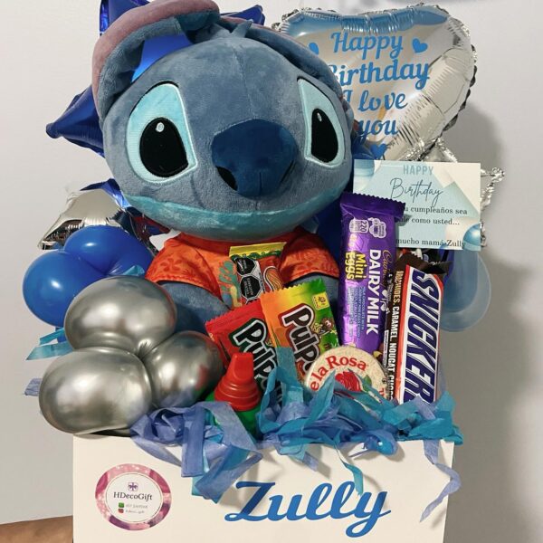 Blue-themed birthday gift box with balloons, plush toy, and assorted snacks