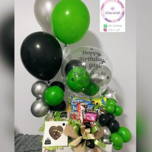 Gift basket with green, black, and silver balloons, snacks, and a gift box with a gold and black bow