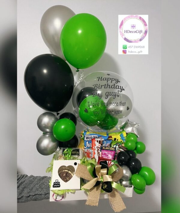 Gift basket with green, black, and silver balloons, snacks, and a gift box with a gold and black bow